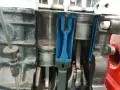 Przekrój silnika pokazuje ruch tłoka w cylindrze. Widoczne są korbowody i wał korbowy.