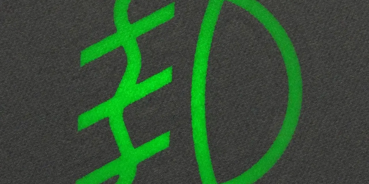 Zielony symbol przeciwmgielny na ciemnym tle.