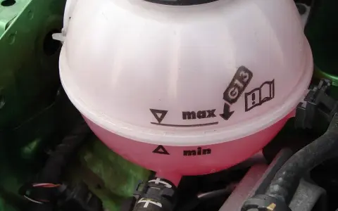 Zbiornik płynu chłodniczego z oznaczeniami "min" i "max". Wskazówki jak uzupełnić płyn chłodniczy, typ G13.