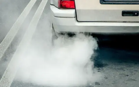 Z tyłu samochodu wydobywa się biały dym. Widać fragment tylnej lampy i tablicy rejestracyjnej. Diesel kopci na biało.