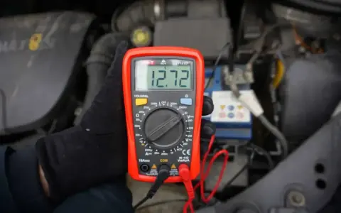 Multimetr pokazuje 12.72V, co może oznaczać, że akumulator nie trzyma napięcia. Sprawdzanie stanu baterii w samochodzie.