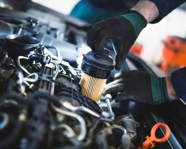 Mechanik wymienia filtr paliwa w silniku. Pamiętaj, co ile wymieniać filtr paliwa, by auto działało sprawnie.