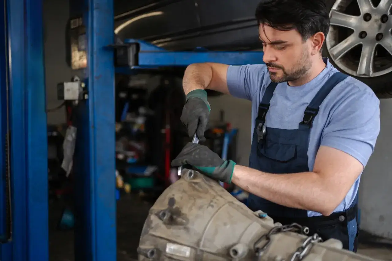 Mechanik naprawia skrzynię biegów, która powoduje szarpanie przy zmianie biegów.