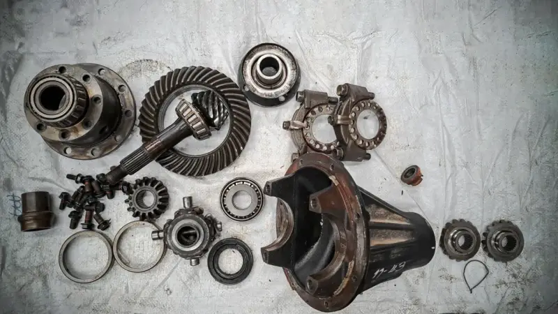 Rozłożony mechanizm różnicowy, gotowy do naprawy. Objawy awarii mogą być różne, od hałasu po problemy z jazdą.